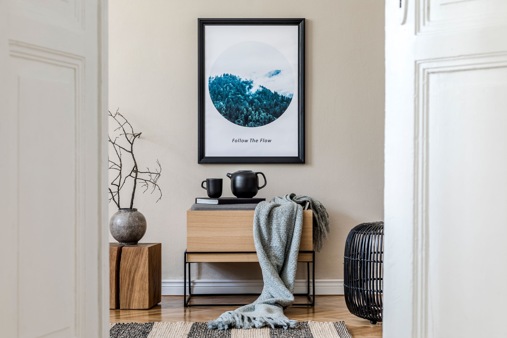 Modern scandinavian living room interior with mock up poster frame, design commode, flower in vase, black rattan basket, books , tea pot and elegant accessories. Template Stylish home staging. Japandi